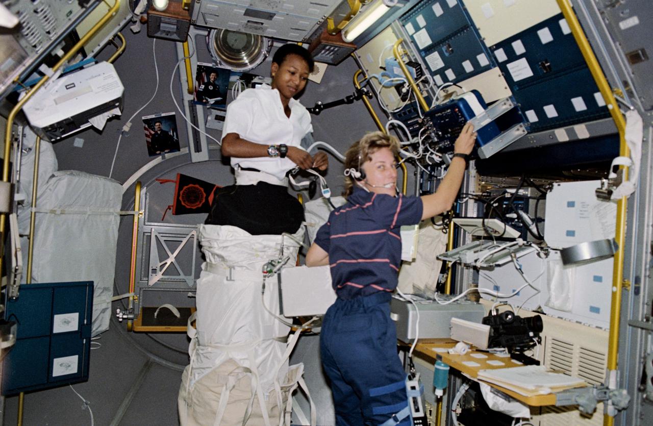 STS047-230-030 (12 - 20 Sept 1992) --- Astronauts Mae C. Jemison (left) and N. Jan Davis, mission specialists, are pictured in the Spacelab-J science module preparing to conduct a session with the Lower Body Negative Pressure (LBNP) experiment.  The two joined four other NASA astronauts and a payload specialist representing Japan's National Space Development Agency (NASDA) aboard the Earth-orbiting Space Shuttle Endeavour for eight days of Spacelab-J research.