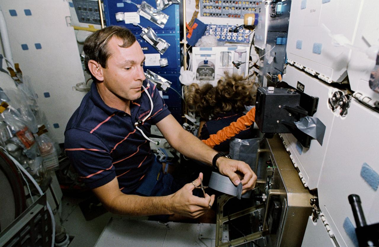 STS047-35-022 (12 - 20 Sept 1992) --- Astronauts Curtis L. Brown, Jr., pilot, and N. Jan Davis, mission specialist, team up to cure a high humidity problem in the hornet experiment in the Spacelab-J Science Module of the Earth-orbiting Space Shuttle Endeavour.  Via a jury-rigged hose hook-up, the two were able to blow air from a spacesuit fan into the experiment, thus eliminating condensation that obscured the viewing of the Israeli hornet experiment.  The experiment examined the effects of microgravity on the orientation, reproductive capability and social activity of 180 female Oriental Hornets.