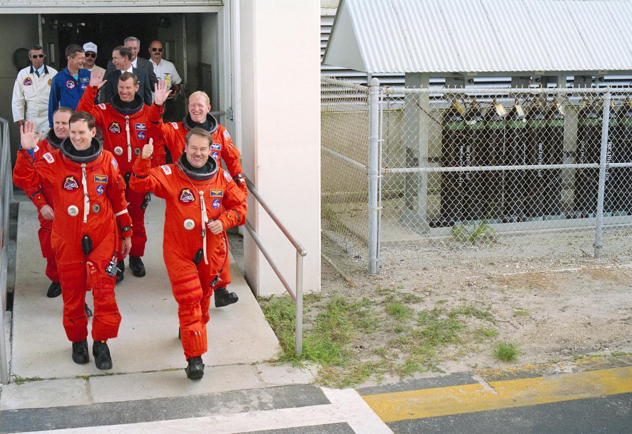 STS048-S-168 (18 Sept. 1991) --- The five astronaut crew members for NASA's STS-48 mission leave the operations and checkout building headed for a transfer van that will take them to the awaiting Discovery at Launch Complex 39.  Astronaut John O. Creighton, right, mission commander, leads the group, with Kenneth S. Reightler, pilot, on his right.  Mission specialists are, left to right, James F. Buchli, Mark N. Brown and Charles D. (Sam) Gemar.  In the background are astronauts Steven R. Nagel and Richard O. Covey and Olan J. Bertrand, all from the Johnson Space Center (JSC).  Discovery launched at 7:11:04 p.m. (EDT), Sept. 12, 1991. Photo credit: NASA