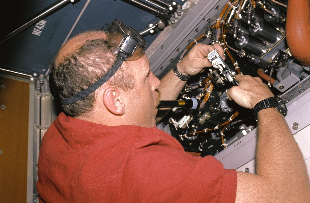 STS050-20-012 (26 June 1992) --- Astronaut Kenneth D. Bowersox, pilot, performs in-flight maintenance (IFM) on the Regenerative Carbon Dioxide Removal System (RCRS) on the mid-deck of the Earth-orbiting Space Shuttle Columbia.  Bowersox was joined by four other astronauts and two scientists from the private sector for a record-setting 14-day stay aboard the Space Shuttle in support of the United States Microgravity Laboratory 1 (USML-1).