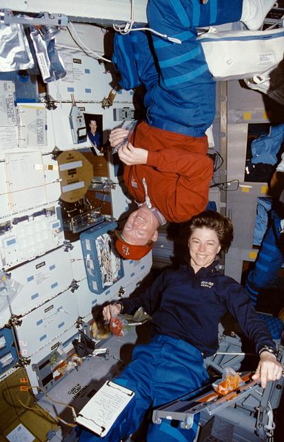 NASA image: Crewmembers eating in the mid deck.