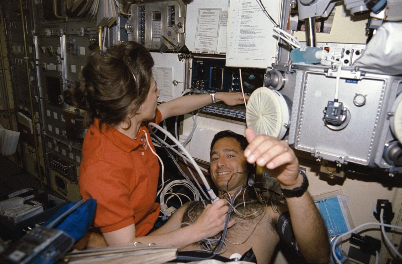 STS050-291-027 (25 June-9 July 1992) --- Astronaut Bonnie J. Dunbar uses a Doppler to collect medical data from Lawrence J. DeLucas, payload specialist, during his diagnostic "run" in the Lower Body Negative Pressure device (LBNP).  The Doppler is used to pick up high-frequency sound waves from the surface of the heart, thus producing pictures on the monitor of the American Flight Echocardiograph (AFE).  The result of the LBNP procedure is expected to be an increased tolerance of orthostatis - or standing upright - upon return to Earth's gravity.  LBNP has been used a number of times in the United States space program, as early as the Skylab missions.  STS-50 is the fourth flight of the current collapsible unit.  Researchers are refining the LBNP protocol which will be used operationally on future 13 through 16 day missions.