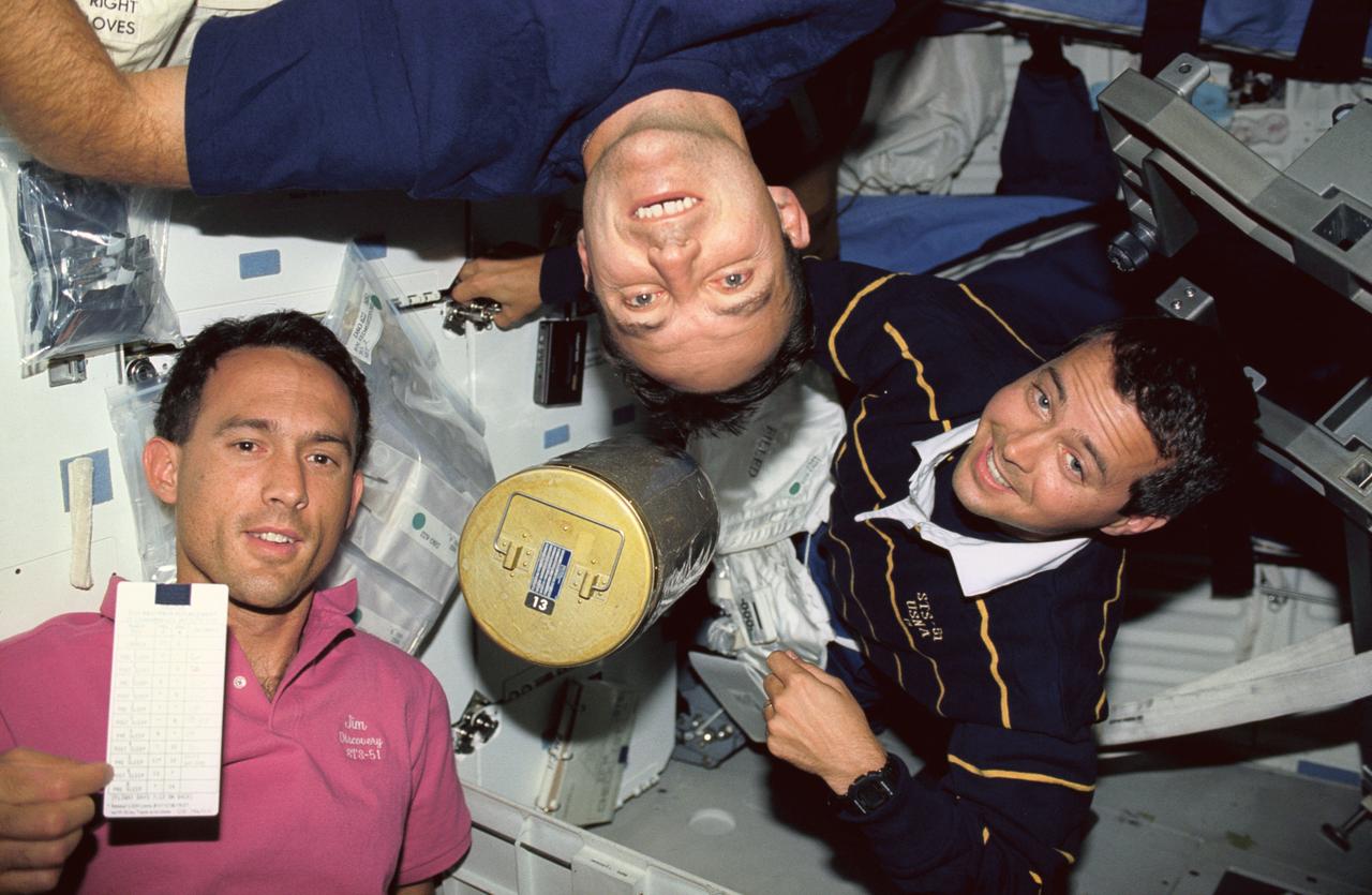 STS051-08-037 (12-22 Sept 1993) --- Three members of the astronaut class of 1990 change out a lithium hydroxide canister beneath Discovery's middeck.  Left to right are astronauts James H. Newman, Carl E. Walz and Daniel W. Bursch, all mission specialists.