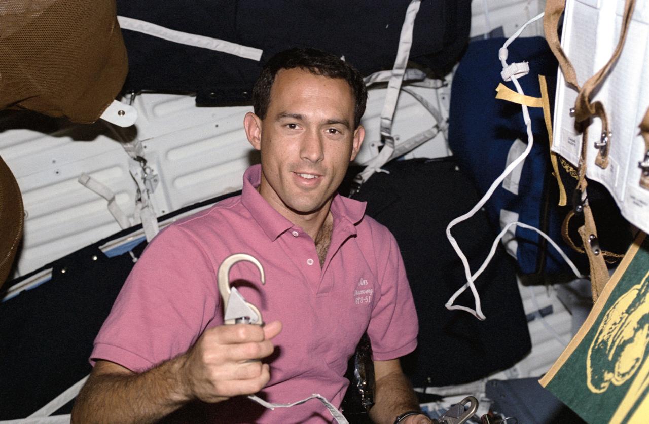 STS051-26-002 (12-22 Sept 1993) --- Astronaut James H. Newman, mission specialist, shows off a latch hook for a tether device used during the STS-51 extravehicular activity (EVA) on September 16, 1993.  Newman, on Discovery's middeck, appears surrounded by sleep restraints.
