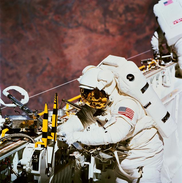 NASA image: Astronaut James Newman works with power ratchet tool in payload bay