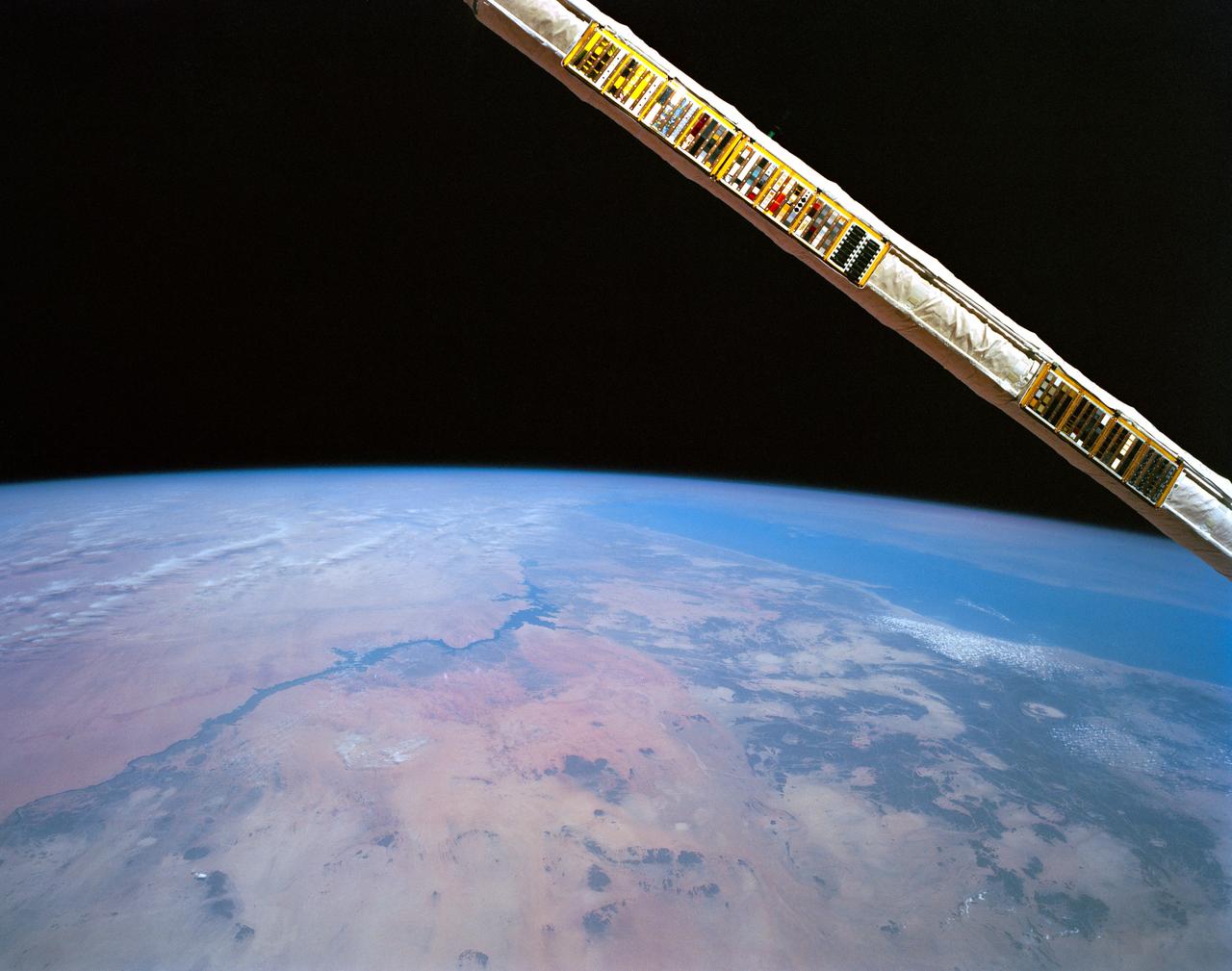 STS052-152-026 (22Oct-1 Nov 1992) --- Backdropped over eastern Egypt, the Canadian-built remote manipulator system (RMS) attached to NASA's Earth-orbiting Space Shuttle Columbia displays a Canadian Space Agency (CSA) experiment. Materials Exposure in Low Earth Orbit (MELEO) is one of a number of Canadian experiments which flew aboard Columbia for the ten-day STS-52 mission. Principal investigator for the experiment is Dr. David G. Zimick of the CSA. Plastic and composite materials used on the external surfaces of spacecraft have been found to degrade in the harsh environment of space. Evidence suggests that this degradation is caused by interaction with atomic oxygen which induces damaging chemical and physical reactions. The result is a loss in mass, strength, stiffness and stability of size and shape. During the mission, MELEO exposed over 350 material specimens mounted on "witness plates" on the RMS arm. The specimen collection will be analyzed in the weeks following the mission. Typical spacecraft materials and new developments in protective measures against atomic oxygen were tested as part of the MELEO experiment.