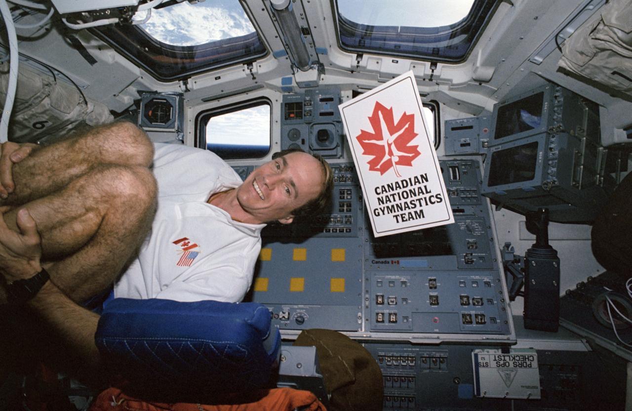 STS052-24-014 (22 Oct-1 Nov 1992) ---  Canadian payload specialist Steven G. MacLean tries out gymnastics in the weightlessness of space on the aft flight deck of the Earth-orbiting Space Shuttle Columbia.  MacLean, along with five NASA astronauts, spent ten days aboard Columbia for the STS-52 mission.