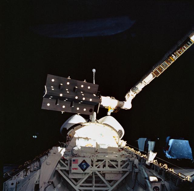 NASA image: STS-52 CANEX-2 Canadian Target Assembly (CTA) held by RMS over OV-102's PLB