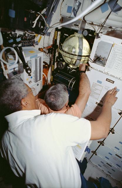 NASA image: Crewmembers in the middeck with the FARE experiment.