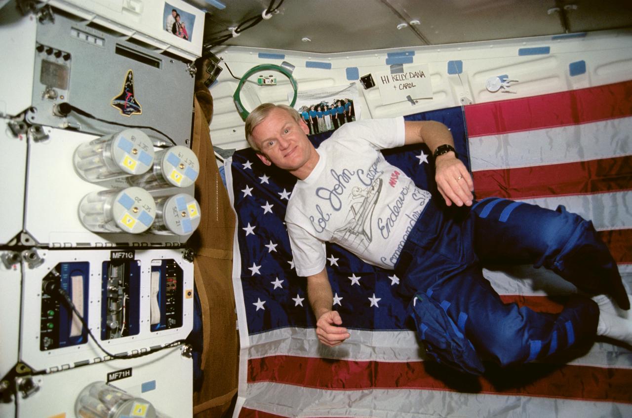 STS054-07-003 (13-19 Jan 1993) --- Astronaut John H. Casper, mission commander, floats near the Commercial Generic Bioprocessing Apparatus (CGBA) station on Endeavour's middeck.  A friction car and its accompanying loop -- part of the Toys in Space package onboard -- can be seen just above Casper's head.  The photograph was taken with a 35mm camera.