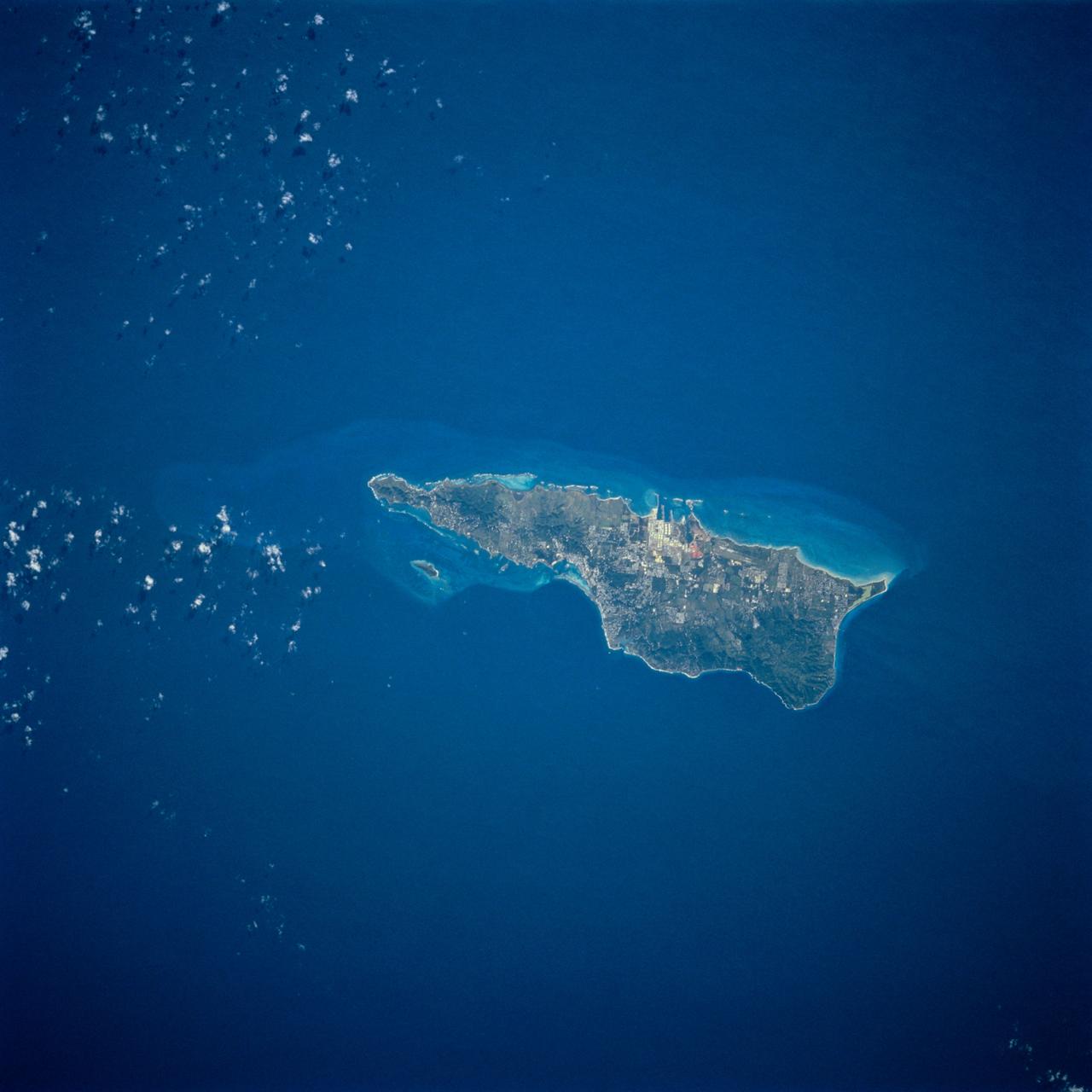 STS054-74-049 (13-19 Jan. 1993) --- St. Croix is the largest, and most industrial of the U.S. Virgin Islands. This photograph captures St. Croix's features in great detail. The large industrial complex in the middle of the southern shore is the world's largest petroleum refinery. The main city, Christiansted, can be seen across the island on the north shore. The reefs around the eastern end of St. Croix are preserved as a submarine national park -- Buck Island Reef National Park -- around the small island off the north shore of the eastern end of St. Croix.