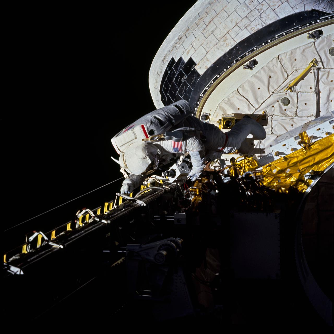 STS054-80-0N (17 Jan 1993) --- Astronaut Gregory J. Harbaugh moves along the starboard side of Endeavour's cargo bay during the four-plus hour long extravehicular activity (EVA) on January 17, 1993.  The photograph was taken with a 70mm camera from inside Endeavour's cabin by a fellow crewmember.  Three astronauts remained inside to support the spacewalk by astronauts Harbaugh and Mario Runco Jr. (out of frame).