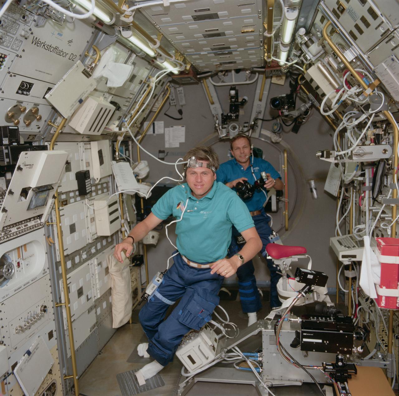 STS055-106-056 (26 April-6 May 1993) --- Ulrich Walter, one of two payload specialists representing the German Aerospace Research Establishment (DLR) onboard Columbia, plants his socked feet into temporary foot restraints.  Walter's headwear telltales his participation in a Tissue experiment.  Fellow payload specialist Hans Schlegel prepares to take a photo in the background.