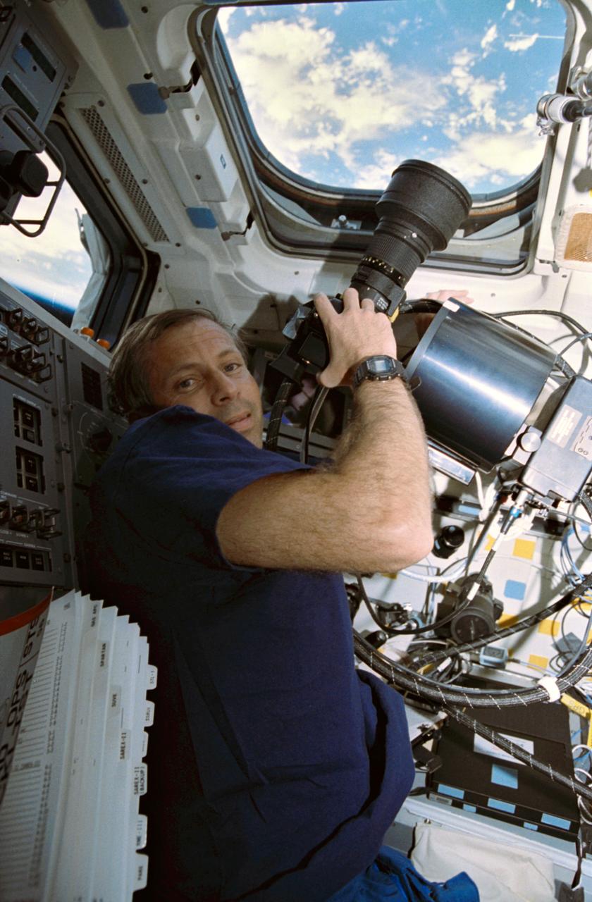 STS056-08-018 (8-17 April 1993) --- Aboard Discovery, astronaut Kenneth D. Cockrell, mission specialist, records Earth imagery with the Hand-Held, Earth-Oriented, Real-Time, Cooperative, User-Friendly, Location-Targeting and Environmental System (HERCULES).  HERCULES is a device that makes it simple for Shuttle crew members to take pictures of Earth, as they merely point a modified 35mm camera and shoot any interesting feature, whose latitude and longitude are automatically determined in real-time.  The powder-box shaped attachment is the Inertial Measurement Unit (IMU) for the system.  The STS-56 crew downlinked a number of the still images during the flight, while others are likely to be stored on disc and returned to Earth with the crew.