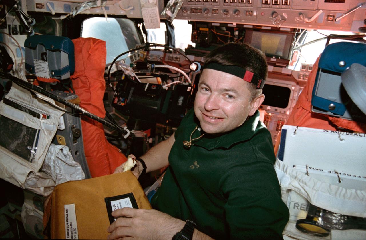 STS056-08-028 (8-17 April 1993) --- Astronaut Kenneth D. Cameron, mission commander, prepares to remove a camera before making exposures with it on Discovery's flight-deck. Cameron and four other NASA astronauts spent nine days in space supporting the Atlas 2 mission.