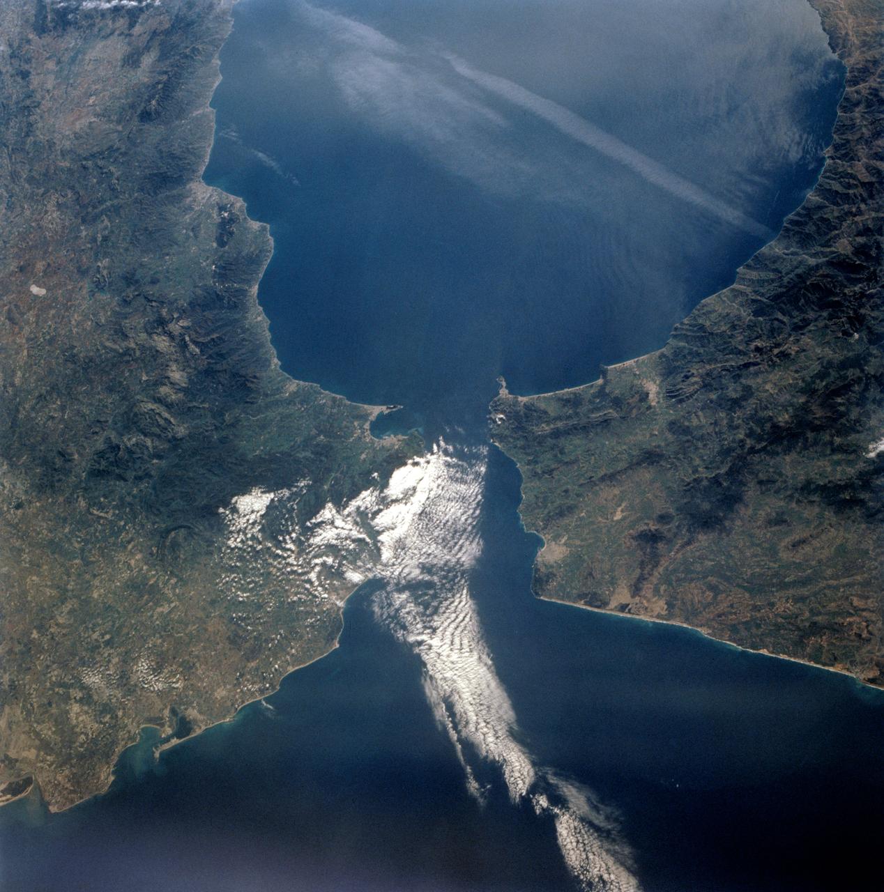 STS-56 Earth observation taken aboard Discovery, Orbiter Vehicle (OV) 103, is of the Strait of Gibraltar. A small bank of clouds marks the passage between Spain and Morocco at the western edge of the Mediterranean Sea. This passage, one of the two Pilars of Hercules of the Ancient Greeks, is now known as the Strait of Gibraltar. The cities of Cadiz on the Atlantic Coast of Spain and Malaga on the Mediterranean coast, as well as Tangier, Morocco (facing the strait), can be seen. According to NASA scientists studying the STS-56 photos, a subtle difference in the water color on the Atlantic side suggests that a pulse of surface water had recently flowed out of the Mediterranean into the Atlantic.