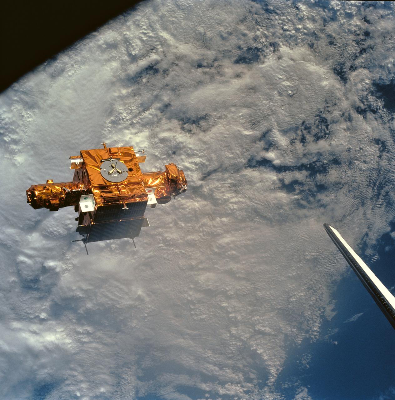 STS056-90-034 (8-17 April 1993) --- Backdropped against heavy cloud cover over the Mediterranean Sea, the SPARTAN-201 satellite was captured on 70mm by crewmembers aboard the Space Shuttle Discovery.  SPARTAN is a free-flying payload designed to study the solar wind and part of the sun's corona.  The project was conceived in the late 1970s to take advantage of the opportunity offered by the Space Shuttle to provide more observation time for the increasingly more sophisticated experiments than the five to ten minutes provided by sounding rocket flights.  On the mission's third day, Astronaut Ellen Ochoa, Mission Specialist, used the remote manipulator system (RMS) to lift the satellite from its support structure on Discovery and release it in space.  The reusable craft was later recaptured and returned to Earth with the crew.  Note the tip of Discovery's vertical stabilizer at frame's edge.