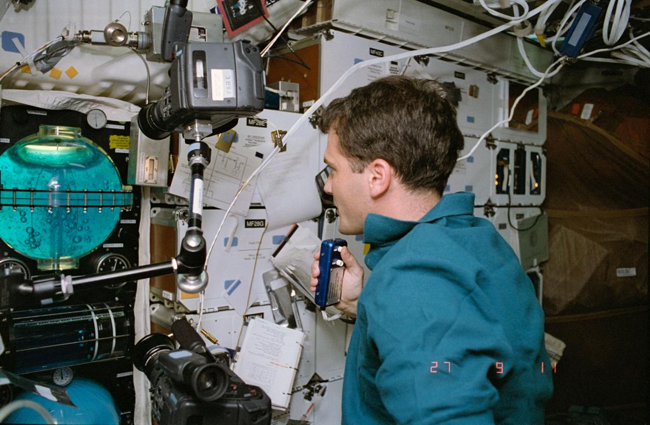 STS057-39-021 (21 June-1 July 1993) --- Astronaut Peter J. K. (Jeff) Wisoff, mission specialist, monitors the Fluid Acquisition and Resupply Experiment (FARE II), housed in four middeck lockers onboard the Space Shuttle Endeavour.  The successor to FARE I (STS 53, 1992), FARE II was designed to demonstrate the effectiveness of a device to alleviate the problems associated with vapor-free liquid transfer.