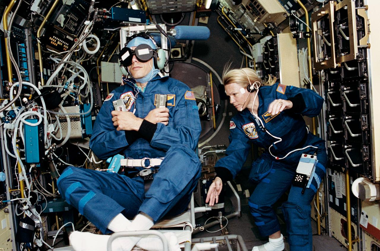 STS058-202-001 (18 Oct.-1 Nov. 1993) --- Astronaut Rhea Seddon, payload commander, spins the Spacelab Life Sciences (SLS-2) rotating chair as payload specialist Martin J. Fettman serves as test subject.  The two joined five NASA astronauts for fourteen days of medical research aboard the Earth-orbiting space shuttle Columbia. Photo credit: NASA