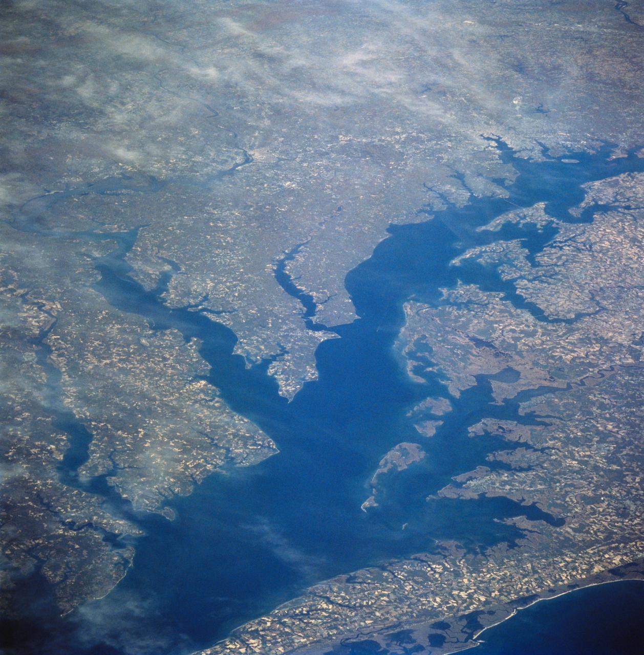 STS058-81-049 (18 Oct-1 Nov 1993) --- This view encompasses most of the large estuarine system of the Chesapeake Bay.  The farmland and marshes of eastern shores of the Chesapeake (eastern Maryland and Virginia) are the foreground.  The largest tributary flowing into the Bay is the Potomac River; Washington, D.C. is visible where the river bends to the northwest.  The urban-suburban corridor between Washington, D.C. and Baltimore to the north (toward the right on this view) shows well as the gray zone which extends from left (D.C. on the Potomac) to right (Baltimore on the Patapsco River embayment on the Chesapeake, near the upper right).