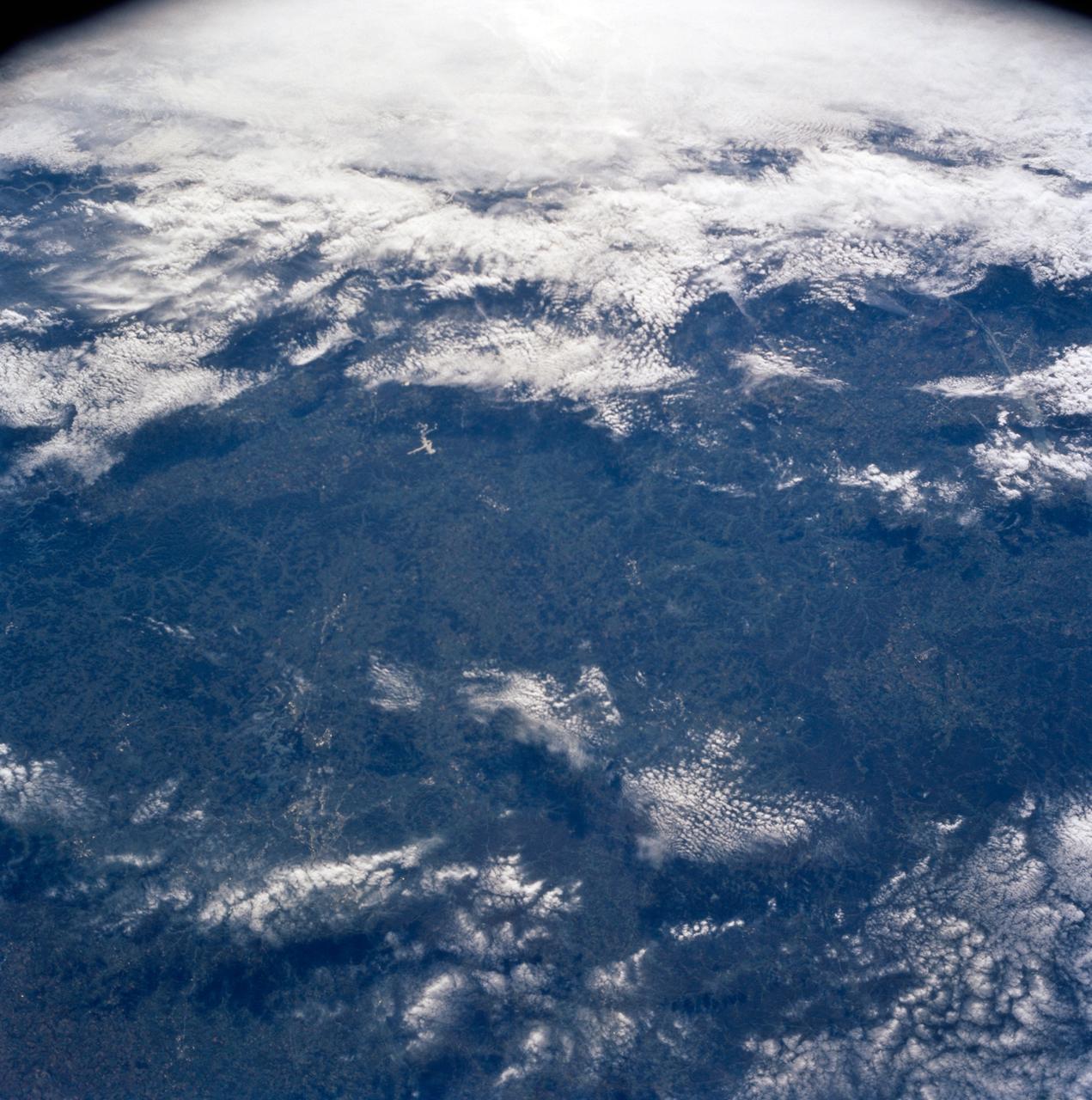 STS058-91-074 (18 Oct-1 Nov 1993) --- The largest cityscape in the view is Nashville (top left), part of which is obscured under a band of clouds (the Cumberland River, on which Nashville lies, can not be seen under the cloud band).  Close to the main cloud mass on the opposite side of the view, lies a small lake (Normandy Lake in sunglint (right center) 70 miles southeast of Nashville.  Between these two features, in the center of the Nashville Basin, lies the city of Murfreesboro.  The city appears here as a spider like pattern one third the distance from Nashville towards Normandy Lake.  The Tennessee River can be seen bottom right and top right through holes in the cloud.