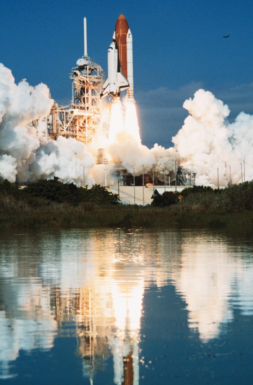 STS058-S-092 (18 Oct 1993) --- The Space Shuttle Columbia, with a crew of seven and a science module aboard, lifts off from Launch Complex 39 at Kennedy Space Center (KSC), leaving its reflection in nearby marsh.  Launch occurred at 10:53 a.m. (EDT), October 18, 1993.  Onboard were astronauts John E. Blaha, Richard A. Searfoss, Rhea Seddon, Shannon W. Lucid, David A. Wolf and William S. McArthur along with payload specialist Martin J. Fettman.