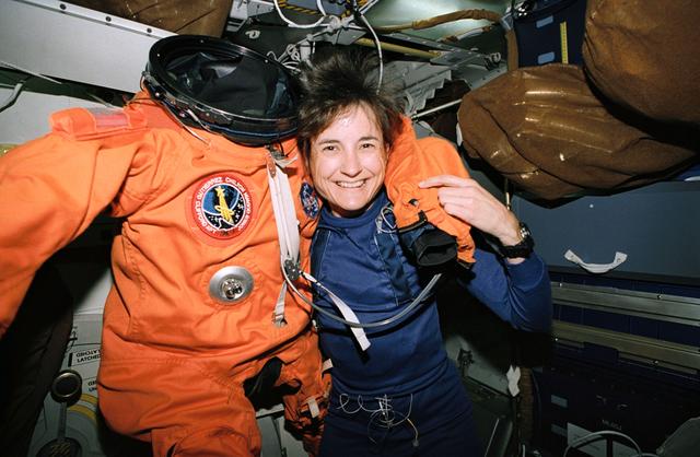NASA image: Astronaut Linda Godwin poses with spacesuit she wore for launch