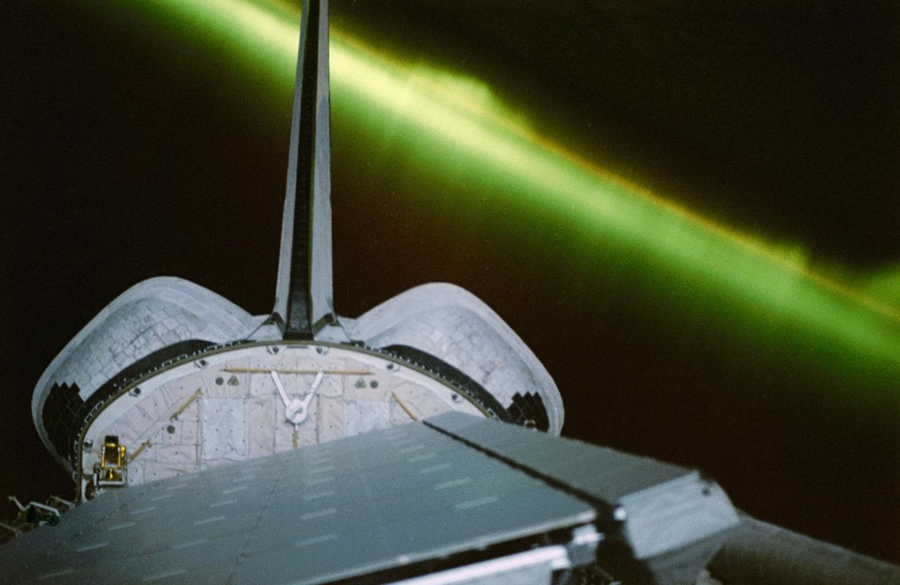 STS059-50-011 (9-20 April 94) --- A greenish appearing aurora forms the backdrop for this 35mm scene of the Earth orbiting Space Shuttle Endeavour's aft cargo bay.  Featured in the bay are the antennae for the SIR-C/X-SAR imaging radar instruments, illuminated by moonlight.  The crew sighted the southern lights (aurora australis) several times during each of the eleven days of the mission.