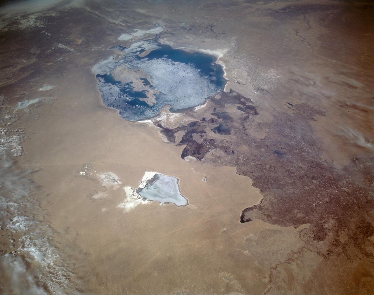 STS059-L22-140 (9-20 April 1994) --- View northeastward across Uzbekastan to the partly-ice-covered Aral Sea and Kazakhstan. The irrigated fan-delta of the Amu Darya extends from the right side of the photograph to end in extensive salt flats at the south end of the sea. The Aral was the fourth-largest inland sea or lake in the world, until diversion and over-use of the river water for irrigation led, in this arid climate, to the sea's decline. Linhof camera.