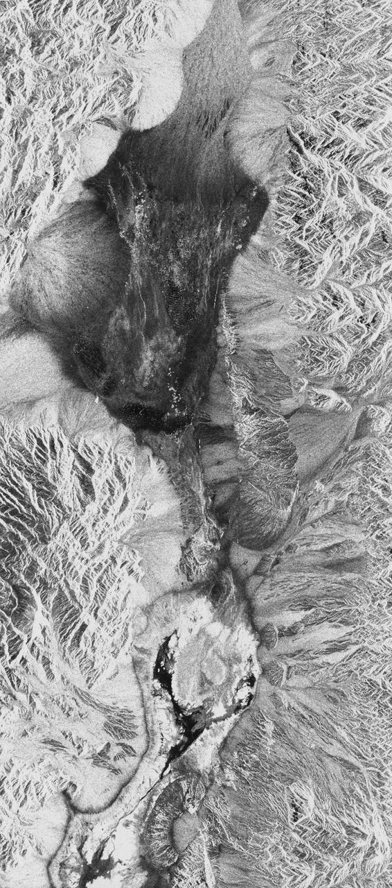 STS059-S-026 (11 April 1994) --- This is an image of Death Valley, California, centered at 36.629 degrees north latitude, 117.069 degrees west longitude.  The image shows Furnace Creek alluvial fan and Furnace Creek Ranch at the far right, and the sand dunes near Stove Pipe Wells at the center.  The dark fork-shaped feature between Furnace Creek fan and the dunes is a smooth flood-plain which encloses Cottonball Basin.  The SIR-C/X-SAR supersite is an area of extensive field investigations and has been visited by both Space Radar Lab astronaut crews.  Elevations in the Valley range from 70 meters below sea level, the lowest in the United States, to more than 3300 meters above sea level.  Scientists are using SIR-C/X-SAR data from Death Valley to help answer a number of different questions about the Earth's geology.  One question concerns how alluvial fans are formed and change through time under the influence of climatic changes and earthquakes.  Alluvial fans are gravel deposits that wash down from the mountains over time.  They are visible in the image as circular, fan-shaped bright areas extending into the darker valley floor from the mountains.  Information about the alluvial fans help scientists study Earth's ancient climate.  Scientists know the fans are bulit up through climatic and tectonic processes and they will use the SIR-C/X-SAR data to understand the nature and rates of weathering processes on the fans, soil formation, and the transport of sand and dust by the wind.  SIR-C/X-SAR's sensitivity to centimeter-scale (or inch-scale) roughness provides detailed maps of surface texture.  Such information can be used to study the occurrence and movement of dust storms and sand dunes.  the goal of these studies is to gain a better understanding of the record of past climatic changes and the effects of those changes on a sensitive environment.  This may lead to a better ability to predict future response of the land to different potential global cimate-change scenarios.  Death Valley is also one of the primary calibration sites for SIR-C/X-SAR.  The bright dots near the center of the image are corner reflectors that have been set-up to calibrate the radar as the Shuttle passes overhead.  Thirty triangular-shaped reflectors (they look like aluminum pyramids) have been deployed by the calibration team from JPL over a 40 kilometer by 40 kilometer area in and around Death Valley.  The calibration team will also deploy transponders (electronic reflectors) and recievers to measure the radar signals from SIR-C/X-SAR on the ground.  Spaceborne Imaging Radar-C and X-Synthetic Aperture Radar (SIR-C/X-SAR) is part of NASA's Mission to Planet Earth (MTPE).  The radars illuminate Earth with microwaves allowing detailed observations at any time, regardless of weather or sunlight conditions.  SIR-C/X-SAR uses three microwave wavelengths: L-Band (24 cm), C-Band (6 cm), and X-Band (3 cm).  The multi-frequency data will be used by the international scientific community to better understand the global environment and how it is changing.  The SIR-C/X-SAR data, complemented by aircraft and ground studies, will give scientists clearer insights into those environmental changes which are caused by nature and those changes which are induced by human activity.  SIR-C was develpoed by NASA's Jet Propulsion Laboratory (JPL).  X-SAR was developed by the Dornire and Alenia Spazio Companies for the German Space Agency, Deutsche Agentur fuer Raumfahrtangelegenheiten (DARA), and the Italian Space Agency, Agenzia Spaziale Italiana (ASI). JPL Photo ID: P-43883