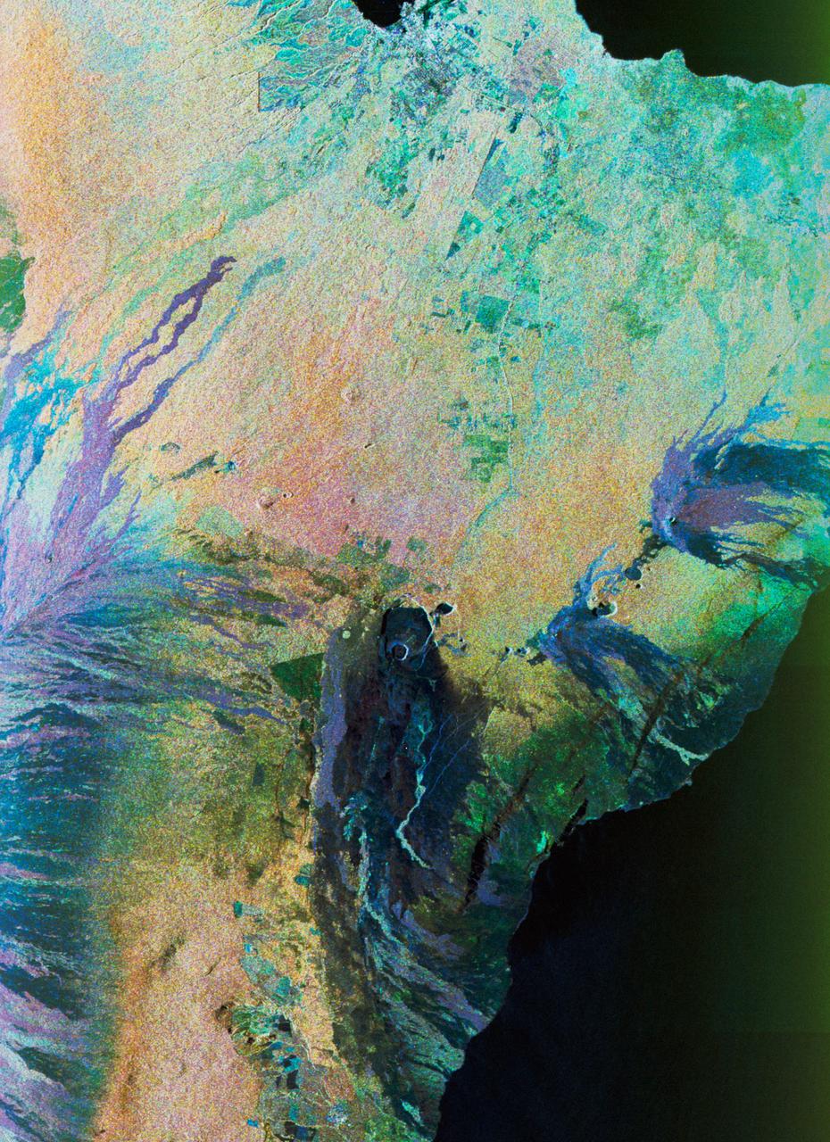 STS059-S-074 (15 April 1994) --- This color composite C-Band and L-Band image of the Kilauea volcano on the big island of Hawaii was acquired by the Spaceborne Imaging Radar-C and X-Band Synthetic Aperture Radar (SIR-C/X-SAR) flying on the Space Shuttle Endeavour.  The city of Hilo can be seen at the top.  The image shows the different types of lava flows around the crater Pu'u O'o.  Ash deposits which erupted in 1790 from the summit of Kilauea volcano show up as dark in this image, and fine details associated with lava flows which erupted in 1919 and 1974 can be seen to the south of the summit in an area called the Ka'u Desert.  In addition, the other historic lava flows created in 1881 and 1984 from Mauna Loa volcano (out of view to the left of this image) can easily be seen despite the fact that the surrounding area is covered by forest.  Such information will be used to map the extent of such flows, which can pose a hazard to the subdivisions of Hilo.  Highway 11 is the linear feature running from Hilo to the Kilauea volcano.  The Kilauea volcano has been almost continuously active for more than the last 11 years.  Field teams that were on the ground specifically to support these radar observations report that there was vigorous surface activity about 400 meters (one-quarter mile) inland from the coast.  A moving lava flow about 200 meters (660 feet) in length was observed at the time of the Shuttle over flight, raising the possibility that subsequent images taken during this mission will show changes in the landscape.  SIR-C/X-SAR is part of NASA's Mission to Planet Earth (MTPE).  SIR-C/X-SAR radars illuminate Earth with microwaves allowing detailed observations at any time, regardless of weather or sunlight conditions.  SIR-C/X-SAR uses three microwave wavelengths: L-Band (24 cm), C-Band (6 cm), and X-Band (3 cm).  The multi-frequency data will be used by the international scientific community to better understand the global environment and how it is changing.  The SIR-C/X-SAR data, complemented by aircraft and ground studies, will give scientists clearer insights into those environmental changes which are caused by nature and those changes which are induced by human activity.  SIR-C was developed by NASA's Jet Propulsion Laboratory (JPL).  X-SAR was developed by the Dornire and Alenia Spazio Companies for the German Space Agency, Deutsche Agentur fuer Raumfahrtangelegenheiten (DARA), and the Italian Space Agency, Agenzia Spaziale Italiana (ASI).    JPL Photo ID: P-43918