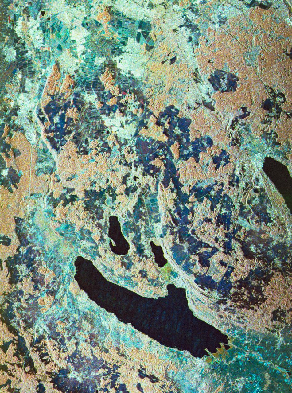 STS059-S-080 (18 April 1994) --- This is a false-color three frequency image of the Oberpfaffenhofen supersite, an area just south-west of Munich in southern Germany.  The colors show the different conditions that the three radars (X-Band, C-Band and L-Band) can see on the ground.  The image covers a 27 by 36 kilometer area.  The center of the site is 48.09 degrees north and 11.29 degrees east.  The image was acquired by the Spaceborne Imaging Radar-C and X-Band Synthetic Aperture Radar (SIR-C/X-SAR) onboard the Space Shuttle Endeavour on April 11, 1994.  The dark area on the left is Lake Ammersee.  The two smaller lakes are the Woerthsee and the Pilsensee.  On the bottom is the tip of the Starnbergersee.  The city of Munich is located just beyond the right of the image.  The Oberpfaffenhofen supersite is the major test site for SIR-C/X-SAR calibration and scientific investigations concerning agriculture, forestry, hydrology and geology.  This color composite image is a three frequency overlay.  L-Band total power was assigned red, the C-Band total power is shown in green and the X-Band VV polarization appears blue.  The colors on the image stress the differences between the L-Band, C-Band, X-Band images.  If the three radar antennas were getting an equal response from objects on the ground, this image would appear in black and white.  However, in this image, the blue areas corresponds to area for which the X-Band backscatter is relatively higher than the backscatter at L and C-Bands.  This behavior is characteristic of grasslands, clear cuts and shorter vegetation.  Similarly, the forested areas have a reddish tint (L-Band).  The green areas seen near both the Ammersee and the Pilsensee lakes indicate marshy areas.  The agricultural fields in the upper right hand corner appear mostly in blue and green (X-Band and C-Band).  The white areas are mostly urban areas, while the smooth surfaces of the lakes appear very dark.  SIR-C/X-SAR is part of NASA's Mission to Planet Earth (MTPE).  SIR-C/X-SAR radars illuminate Earth with microwaves allowing detailed observations at any time, regardless of weather or sunlight conditions.  SIR-C/X-SAR uses three microwave wavelengths: L-Band (24 cm), C-Band (6 cm), and X-Band (3 cm).  The multi-frequency data will be used by the international scientific community to better understand the global environment and how it is changing.  The SIR-C/X-SAR data, complemented by aircraft and ground studies, will give scientists clearer insights into those environmental changes which are caused by nature and those changes which are induced by human activity.  SIR-C was developed by NASA's Jet Propulsion Laboratory (JPL).  X-SAR was developed by the Dornire and Alenia Spazio Companies for the German Space Agency, Deutsche Agentur fuer Raumfahrtangelegenheiten (DARA), and the Italian Space Agency, Agenzia Spaziale Italiana (ASI).    JPL Photo ID: P-43930