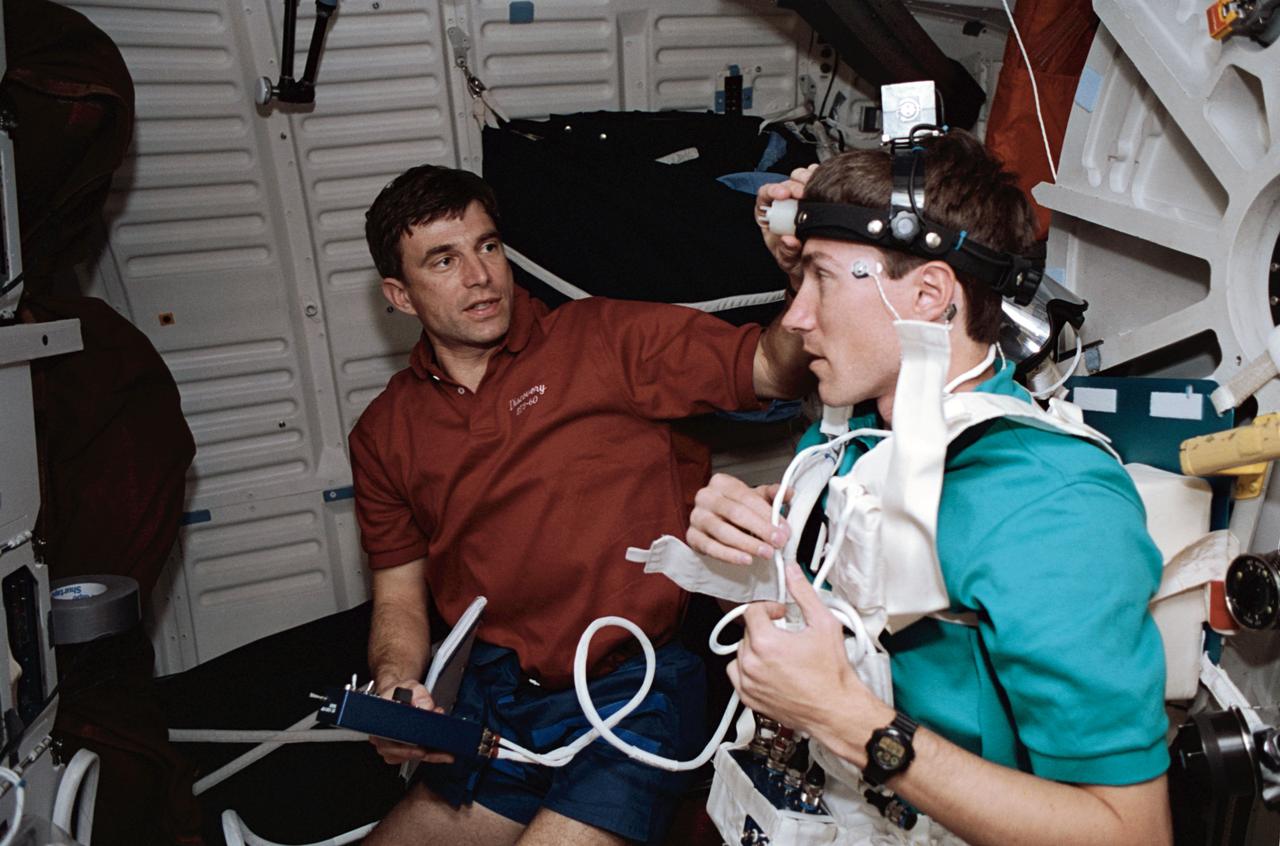 STS060-21-027 (3-11 Feb 1994) --- Astronaut Ronald M. Sega (left) and Russian cosmonaut Sergei K. Krikalev work on a joint U.S./Russian metabolic experiment on the Space Shuttle Discovery's middeck.  A number of other U.S./Russian cooperative Detailed Supplementary Objectives (DSO) are included among the experiments conducted on the eight-day mission.