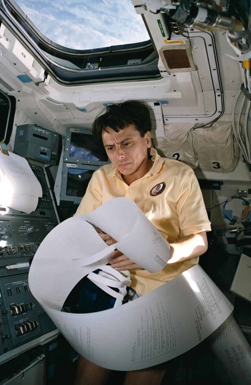 STS060-25-016 (6 Feb. 1994) --- On space shuttle Discovery?s aft flight deck, astronaut Franklin R. Chang-Diaz, STS-60 payload commander, begins to organize what was believed to be among the longest mail messages in shuttle history. Though early shuttle flights could brag of longer teleprinted messages, the Thermal Imaging Printing System?s day four correspondence, most of which is out of frame here, is record length for recent flights. Chang-Diaz joined four other NASA astronauts and a Russian cosmonaut for eight days aboard Discovery. Photo credit: NASA or National Aeronautics and Space Administration