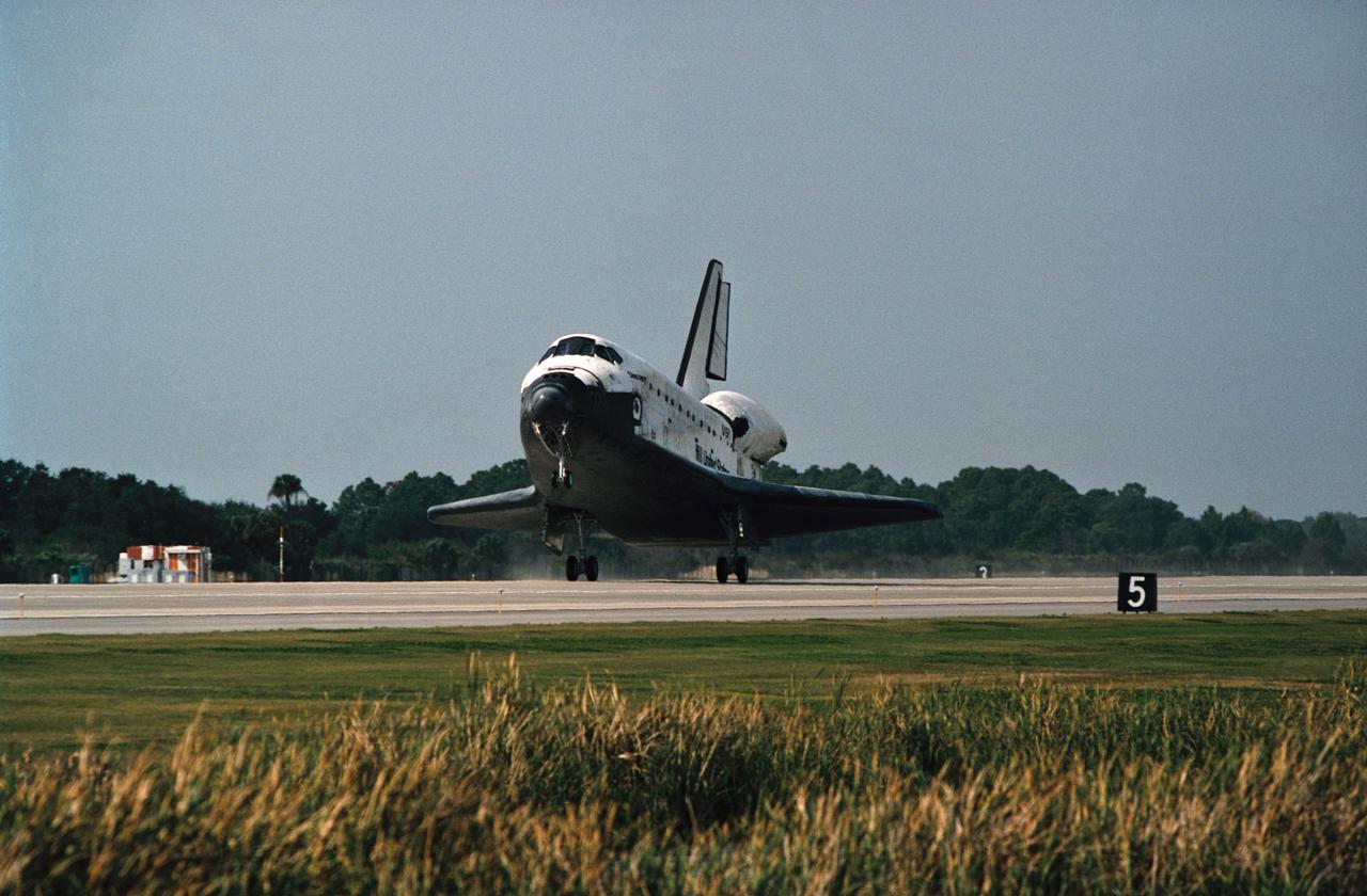The drag chute for Space Shuttle Discovery is deployed on the Shuttle Landing Facility, marking the end to the eight-day STS-60 mission. Landing occurred at 2:19:22 p.m. (035); The main landing gear on the Space Shuttle Discovery touches down on the Shuttle Landing Facility (036); The main landing gear on the Space Shuttle Discovery is about to touch down on the Shuttle Landing Facility. Note the Shuttle Training Aircraft (STA) monitoring the landing phase of the mission (037).