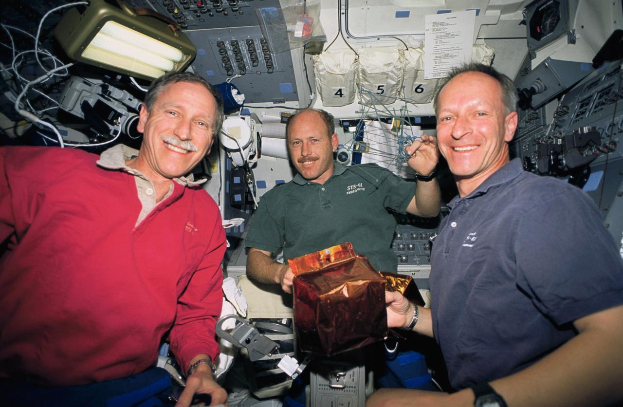 STS061-23-005 (8 Dec 1993) --- Three members of the STS-61 crew prepare covers to be placed on magnetometers near the top of the Hubble Space Telescope (HST).  Left to right are Richard O. Covey, mission commander; Kenneth D. Bowersox, pilot and Claude Nicollier, mission specialist.  On the following day, astronauts Jeffrey A. Hoffman and F. Story Musgrave placed the covers on the magnetometers as they wrapped up five days of servicing on HST.