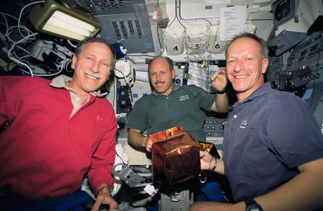 NASA image: STS-61 crewmembers prepare covers for magnetometers on HST