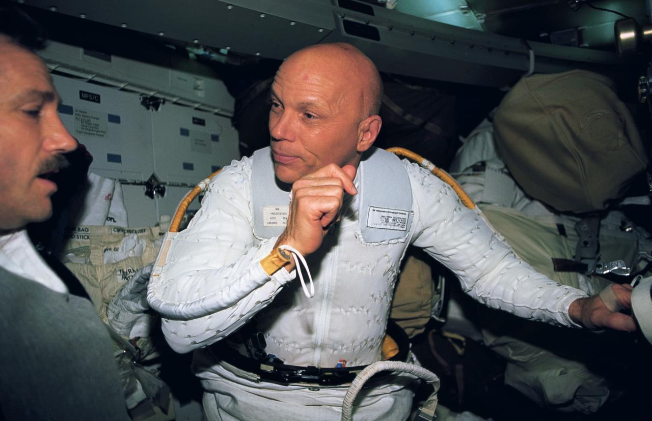 STS061-38-014 (9 Dec 1993) --- Astronaut F. Story Musgrave gets assistance from astronaut Thomas D. Akers while suiting up for the final space walk on the eleven-day, Hubble Space Telescope (HST) servicing mission.  Musgrave joined astronaut Jeffrey A. Hoffman (out of frame) on three space walks, while Akers teamed with astronaut Kathryn D. Thornton for two.