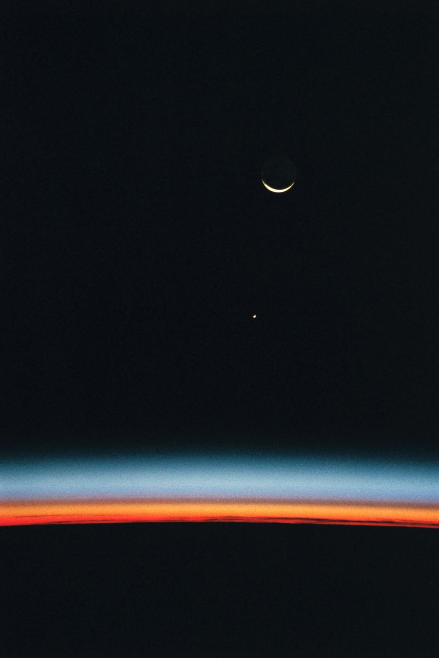 STS061-56-027 (2-13 Dec 1993) --- This scene, captured with a 35mm camera from inside the Space Shuttle Endeavour, shows Jupiter rising above the airglow over Earth's horizon. The crescent Moon is at top frame.