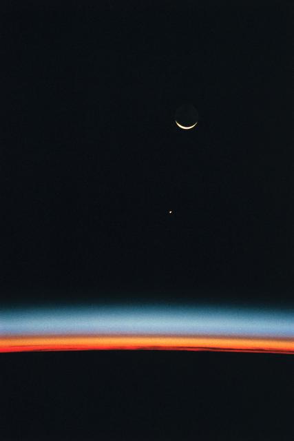 NASA image: Earth-orbiting HST, airglow over Earth's horizon, and crescent moon