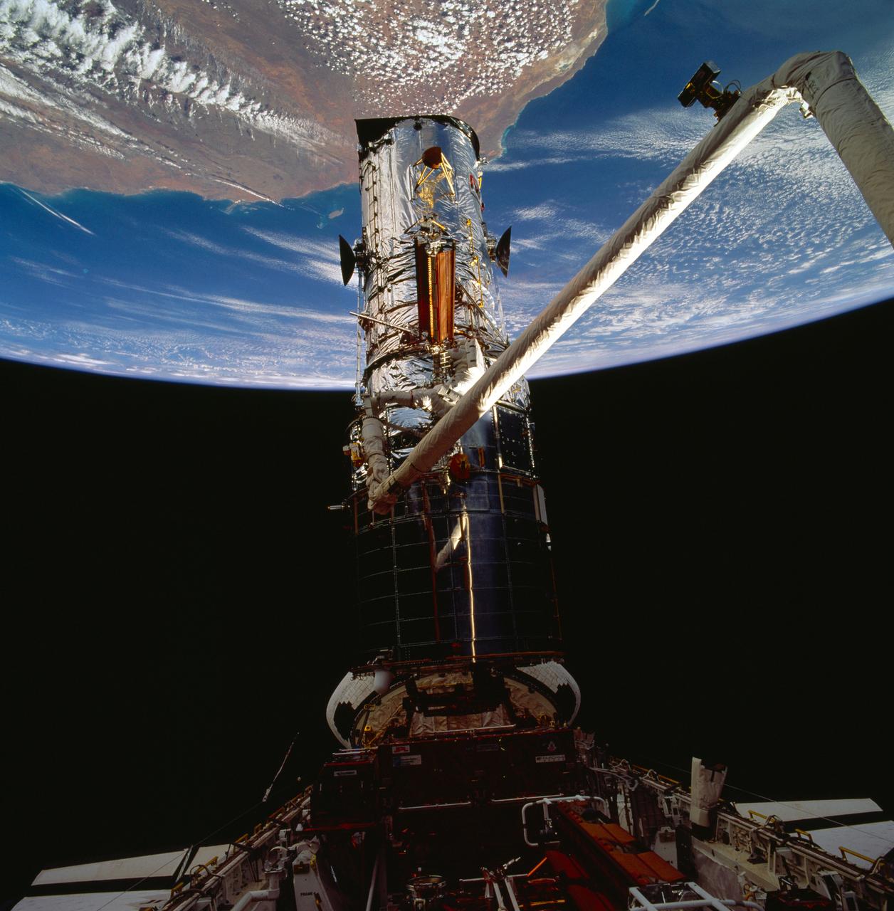 STS061-95-075 (6 Dec 1993) --- Astronauts Kathryn C. Thornton and Thomas D. Akers work to remove one of the solar arrays on the Hubble Space Telescope (HST) on the second of five extravehicular activity?s (EVA).  The two space walkers later replaced both solar array panels.  Part of Australia is in the background.