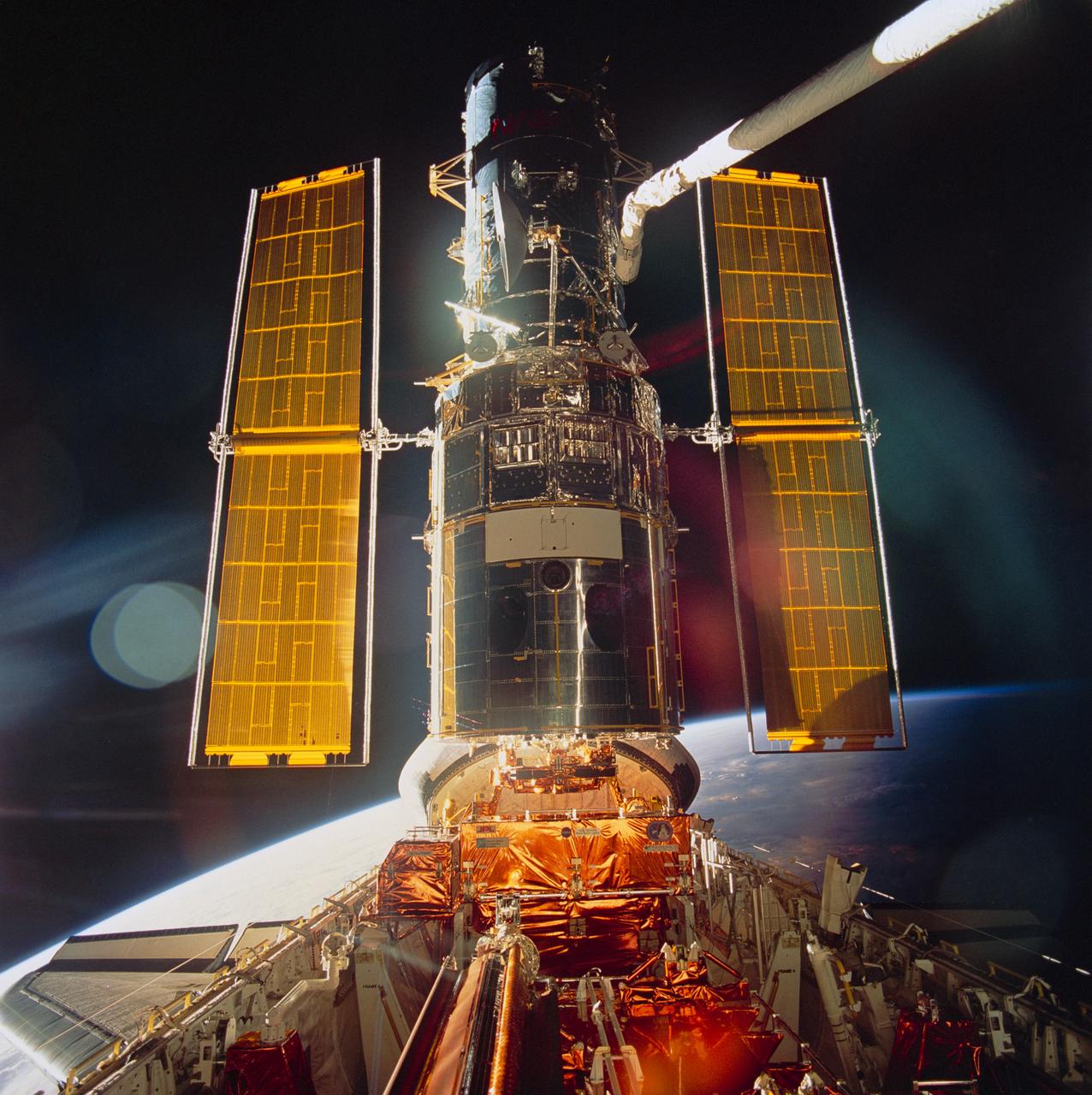 STS061-99-009 (9 Dec 1993) --- Sunlight reflects off the Space Shuttle Endeavour's aft windows and the shiny Hubble Space Telescope (HST) prior to its post-servicing deployment near the end of the eleven-day mission.  A handheld Hasselblad camera was used inside Endeavour's cabin to record the image.