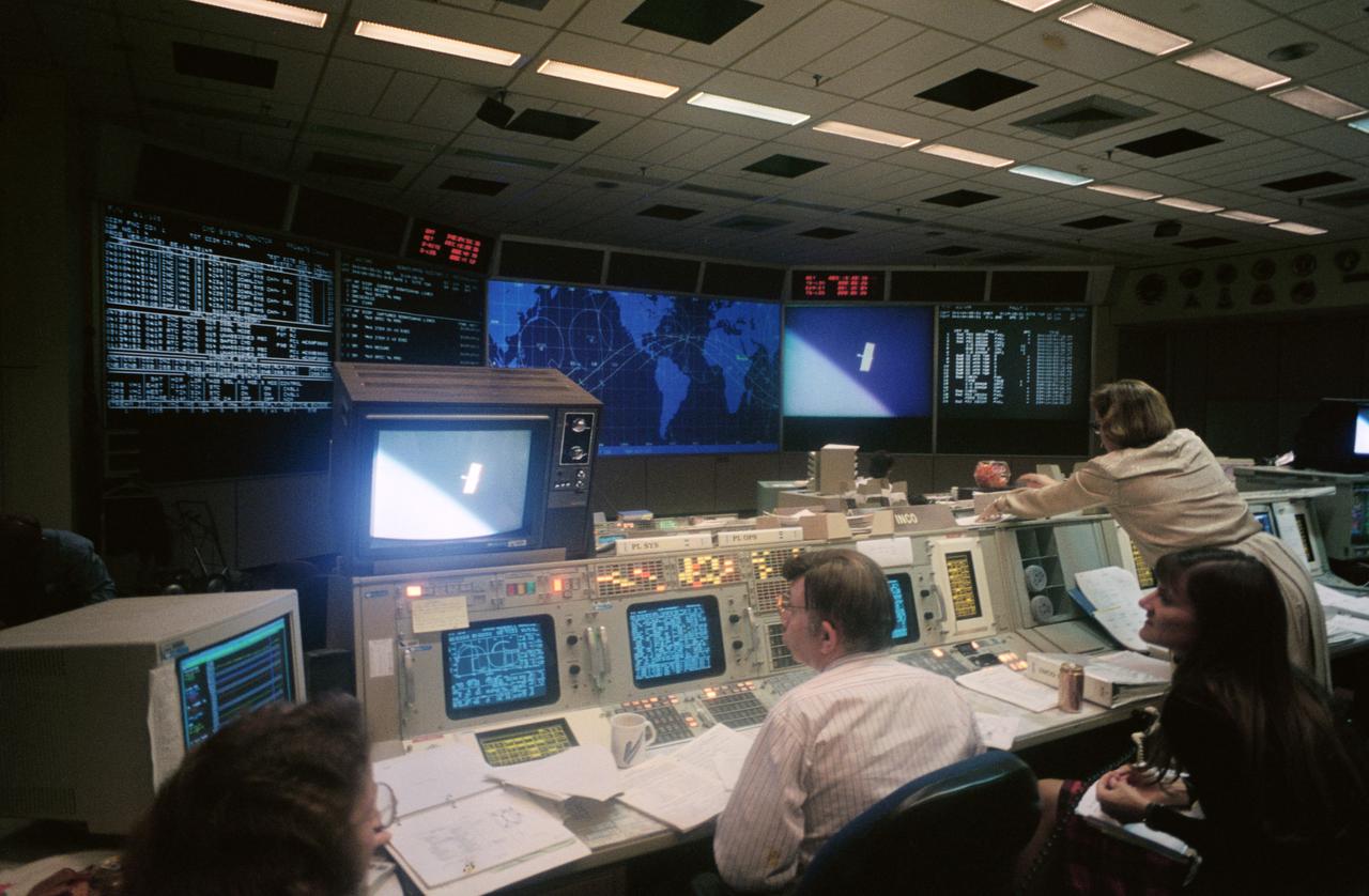 Harry Black, at the Integrated Communications Officer's console in the Mission Control Center (MCC), monitors the second extravehicular activity (EVA-2) of the STS-61 Hubble Space Telescope (HST) servicing mission. Others pictured, left to right, are Judy Alexander, Kathy Morrison and Linda Thomas. Note monitor scene of one of HST's original solar array panels floating in space moments after being tossed away by Astronaut Kathryn C. Thornton.