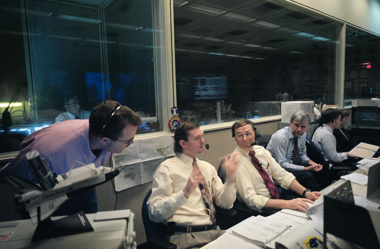 STS61-S-094 (5 Dec 1993) --- Kyle Herring, second left, illustrates a point during mission commentary for the second Extravehicular Activity (EVA-2) of the STS-61 Hubble Space Telescope (HST) servicing mission.  Astronaut Jerry L. Ross (center), a space walker on two previous NASA shuttle missions, amplified Herring's explanations.  At the flight surgeon's console is Dr. Klaus Lohn (third right) of the Institute for Flight Medicine in Koln, Germany.