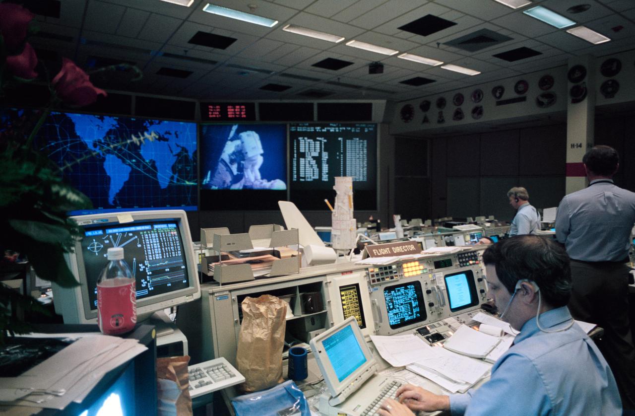 STS061-S-103 (2-13 DEC 1993) --- Flight director Robert E. Castle uses a lap top computer to aid his busy tasks during one of the five space walks performed to service the Hubble Space Telescope (HST) temporarily berthed in the Space Shuttle Endeavour's cargo bay.  STS-61 lead flight director Milt Heflin is at right edge of frame.