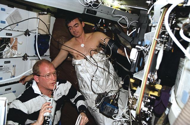 NASA image: Astronauts Gemar and Allen work with lower body negative pressure experiment