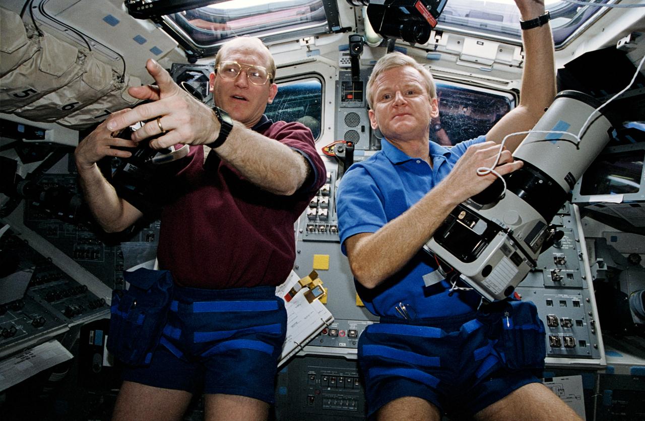 STS062-06-030 (4-18 March 1994) --- With cameras in hand two of the STS-62 astronauts prepare to take pictures of their home planet.  John H. Casper (right), mission commander, handles a large format, Linhof camera, while Charles D. (Sam) Gemar, mission specialist, has just added a roll of film to a 70mm handheld Hasselblad camera.  Earth observations and documentation occupied muc of the on-duty time of all five of the STS-62 crewmembers during their 14-day mission in earth orbit.
