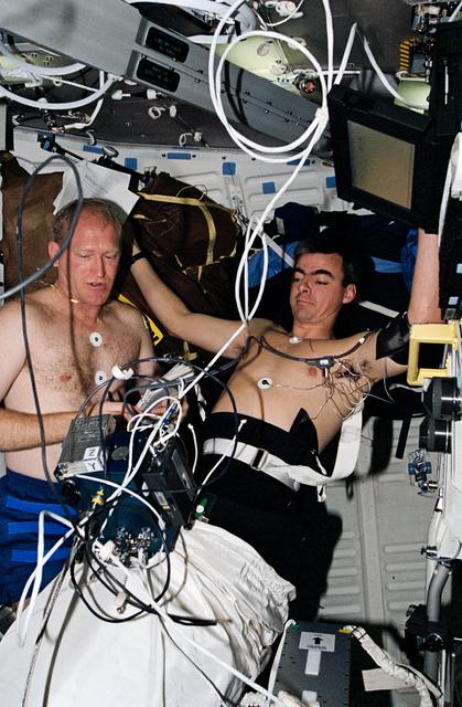 NASA image: Astronauts Gemar and Allen work with lower body negative pressure experiment