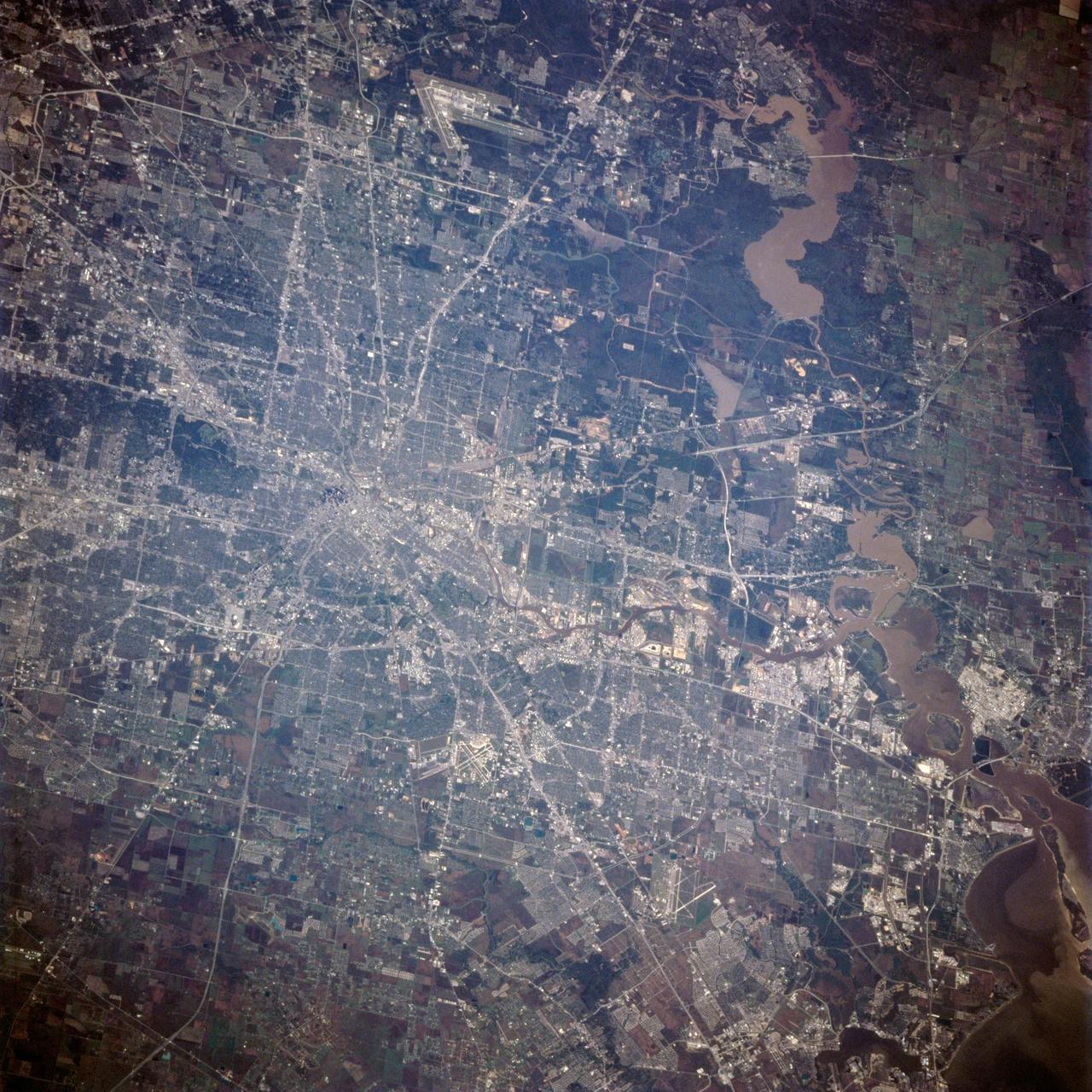 STS062-106-094 (4-18 March 1994) --- The Greater Houston metropolitan area, completely clear of clouds, was captured on 70mm film by one of the crew members aboard the Space Shuttle Columbia.  The belt system on the north, east and south sides of the city can be traced in the frame, though not completed.  The west belt is just out of frame on the left side.  Houston Intercontinental Airport is at top center.  The NASA Johnson Space Center (JSC) and Nassau Bay can be traced inland from the portion of Galveston Bay in the lower right corner.  Not only the dome proper of Harris County Domed Stadium is visible but so are two other structures in the Astrodome complex (left center), Astro Arena and Astrohall.