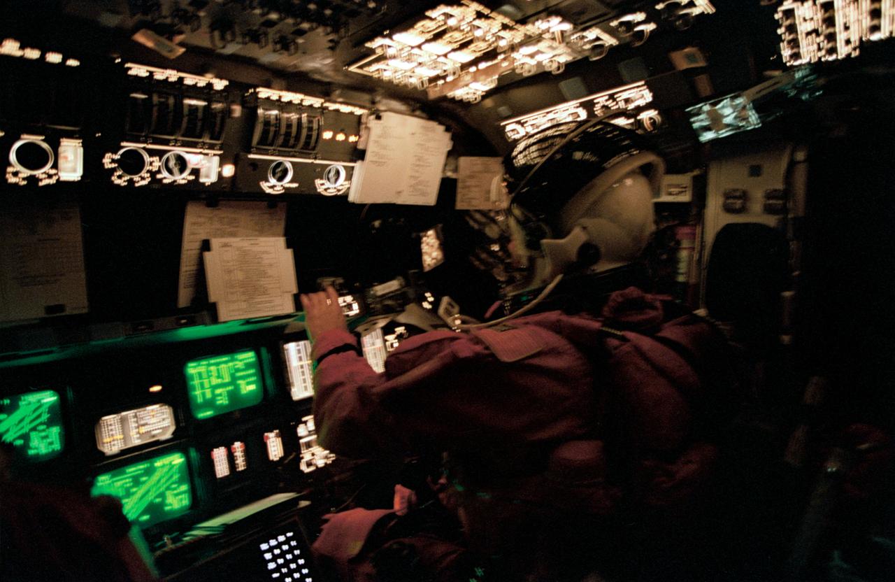 STS062-41-025 (18 March 1994) --- Astronaut Andrew M. Allen monitors Columbia's systems from the pilot's station during the entry phase of the STS-62 mission. The fast-speed 35mm film highlights the many controls and displays and the cathode ray tubes on the forward flight deck.